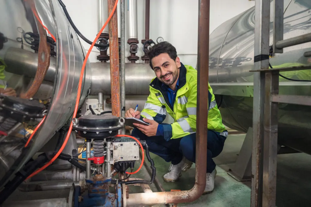 Caucasian engineer man in uniform checklist with clipboard sitti